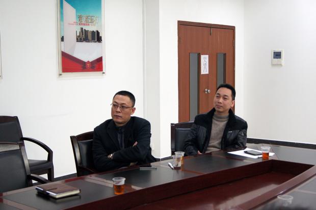 图5、pp电子游戏抛光砖销售副总张彦（左一）、pp电子游戏广东线销售副总庞永江（右一）认真寓目参评专卖店幻灯片播放效果